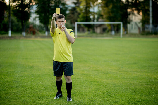 Soccer referee to point out a yellow card to a player in the soccer stadium