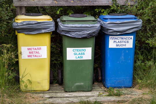 Three multi-colored containers for separate waste collection / Russian translation: metal, glass, plastic