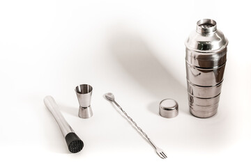 Professional bartender kit set. Cocktail shaker, bar spoon, Jigger and Muddler isolated on white...