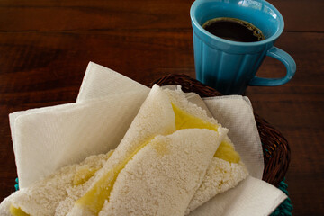 Duas tapiocas recheadas com mussarela e uma xícara de café.