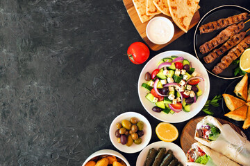 Greek food side border, top view on a dark background. Souvlaki, gyros wraps, salad, spanakopita,...