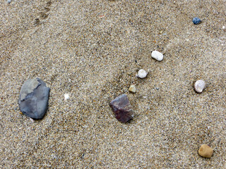 Dessin de pierres sur une plage au sable râpeux 