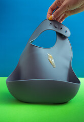 gray silicone bib with a drop of puree.Serving baby food.baby bib