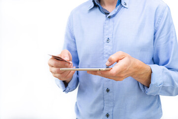 Man with tablet and credit card in hands and blue shirt on white background. Copy space.