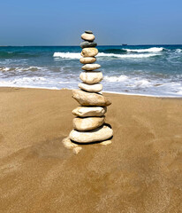 Fototapeta na wymiar Zen meditation relaxation concept background - balanced stones stack close up on sea beach. High quality photo