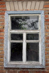 old shabby window in a brick house