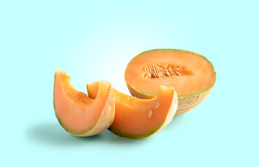 Cantaloupe cut in half and slice on blue background with copy space