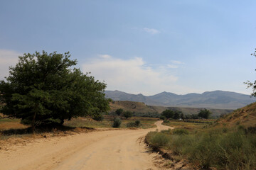 dirt road to Sarykum largest sand dune in Europe under hot summer sky