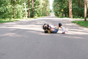 baby in protective sportswear. little girl got a knee injury while roller skating in the park.