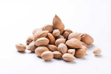 Almonds with shell, Prunus amygdalus heaped on white background