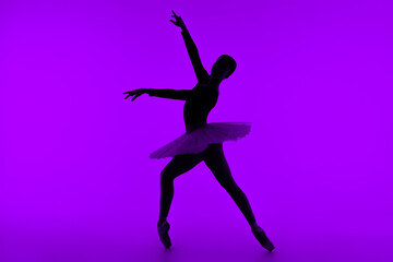 Fototapeta na wymiar Professional ballet dancer on purple studio wall with violet light. Sensual ballerina dancing. Beautiful silhouette of woman in tutu dress. Solo performance.