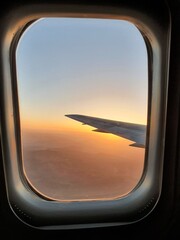 View of the sky and the wing with the iluminator of the aircraft. Lovely sunset, mountains and atmosphere of travel.