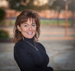 Portrait happy smiling middle age brunette woman outdoors in black dress - 448145455