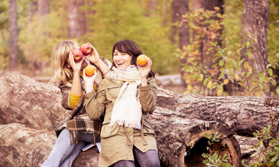 Two happy girlfriends laughing carelessly and enjoying their age and life