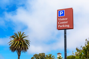 Visitor Center Parking sign. Palm tree, Overcast