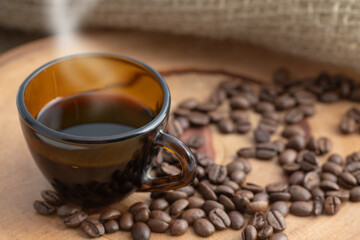 cup of brown coffee on a rustic background and scattered beans