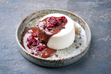 Modern style traditional blancmange almond pudding with cherry and chocolate cream and crumbles...