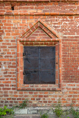 Fototapeta na wymiar medieval window with iron shutters in a brick wall