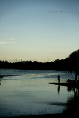 Silhouette of a man fishing in a lake