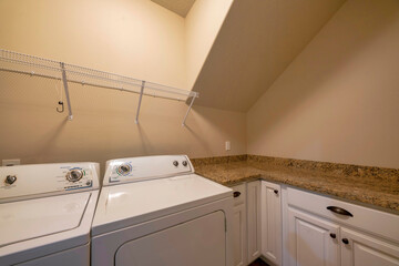 Windowless laundry room interior with L-shape counter