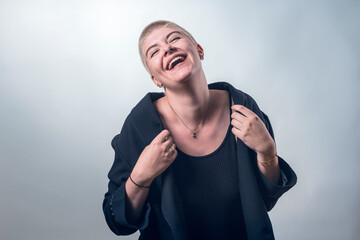 studio shot of a young, strong, laughing woman with very short blond hair