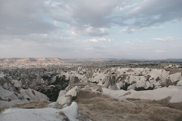 Valley in Cappadocia during sunset and natural formation of volcanic remains in stone in centuries with sky background.