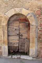 Fototapeta na wymiar Old Wooden Door with Historic Stone Arch in Central Italy Rural Village