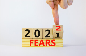Business concept of planning 2022 fears symbol. Businesman turns a wooden cube and changes words 'Fears 2021' to 'Fears 2022'. Beautiful white background, copy space. Business and fears 2022 concept.