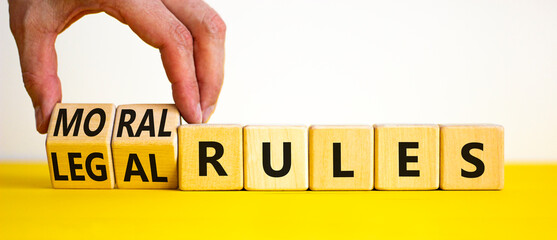 Legal or moral rules symbol. Businessman turns wooden cubes and changes words 'legal rules' to...