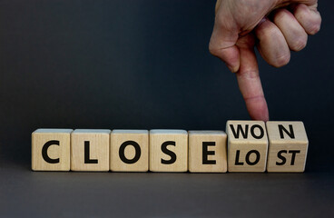 Close won or lost symbol. Businessman turns wooden cubes and changes words Close won to close lost. Beautiful grey background, copy space. Business and close won or lost concept.