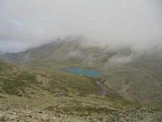 The Caucasus is Russia. View of the mountain lake from an altitude of 3035 meters, clouds and mist