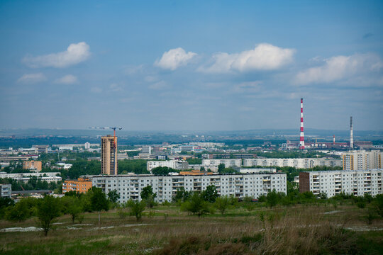 An industrial city on the horizon against the backdrop of a cloudy sky.