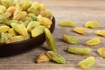 Dried fruits, green raisins on wooden table.
