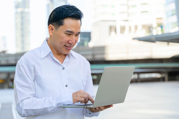 Business Asian man using laptop computer on business district urban - lifestyle business people concept