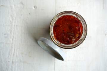 Homemade chili sauce made from organic chilies and then stored in a glass jar  