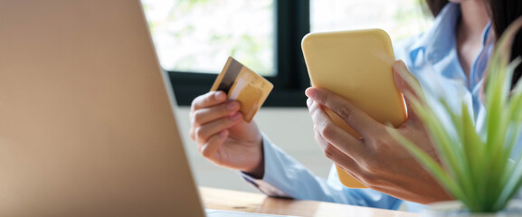 Online payment woman's hands holding smartphone and using credit card for online shopping. Cyber Monday Concept