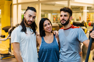 Hispanic young gym friends looking at camera. three people