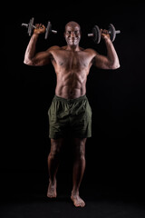 Fototapeta na wymiar Athletic adult man doing shoulder exercise with dumbbells on a black background