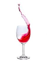 Red wine splash into glass on white background.