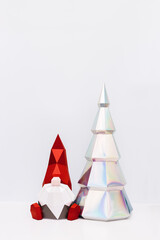 Cute Christmas gnome and holographic paper Christmas tree, paper polygonal figures dwarf and fir tree