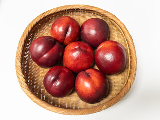 Obraz premium Sweet red nectarines in a bamboo basket