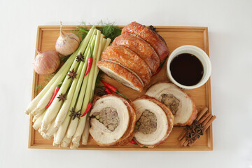 bbq roasted pork meat roll stuffed with special ingredients serve with chef sauce in white background Christmas festival menu