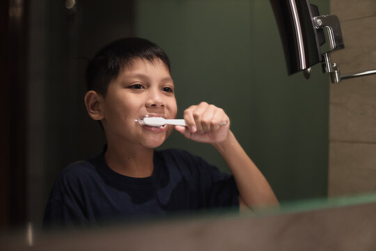 Asian boy brushing teeth in the bathroom