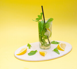 Summer refreshing Mojito cocktail on a light background. Drink with mint, lemon and ice