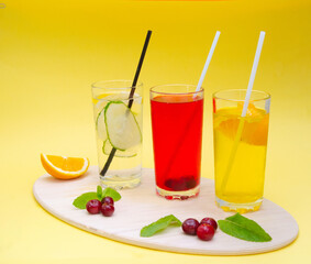 A set of summer refreshing cocktails with ice on a light background