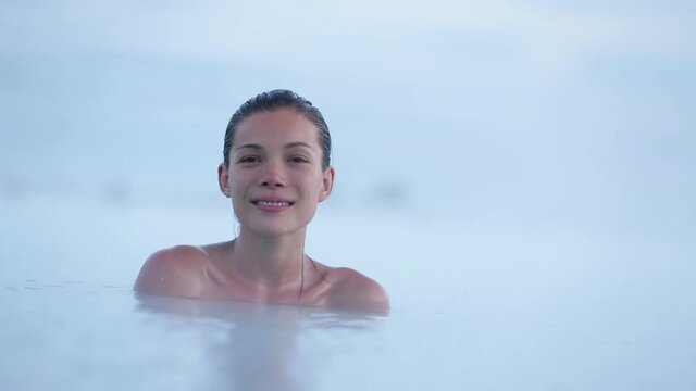 Iceland geothermal spa. Woman relaxing in hot spring pool on Iceland. Girl enjoying bathing in a blue water lagoon Icelandic tourist attraction