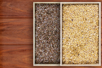 top view of brown and golden flaxseeds or brown and golden linseed (Linum usitatissimum) in a rectangular wooden boxes