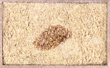 top view of flour golden flaxseeds or golden linseed (Linum usitatissimum) in a rectangular wooden box