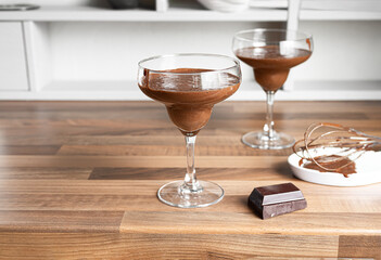 Two bowls with traditional French chocolate mousse on the countertop of a Scandinavian-style kitchen with copy space
