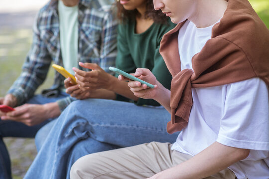 Group of people with smratphones sitting on the bench
